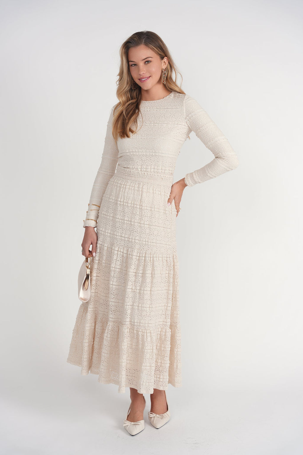 Woman wearing a long beige dress with a white background