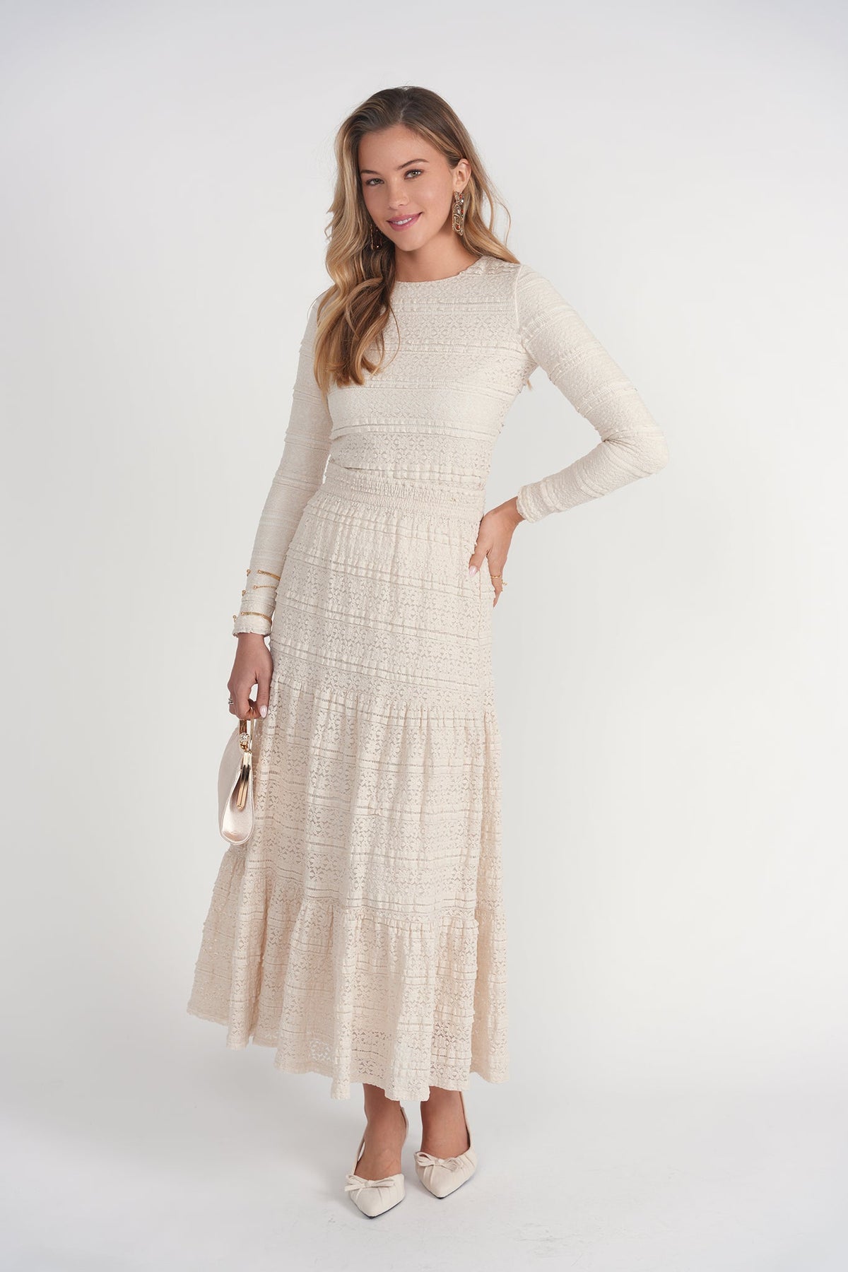 Woman wearing a long beige dress with a white background
