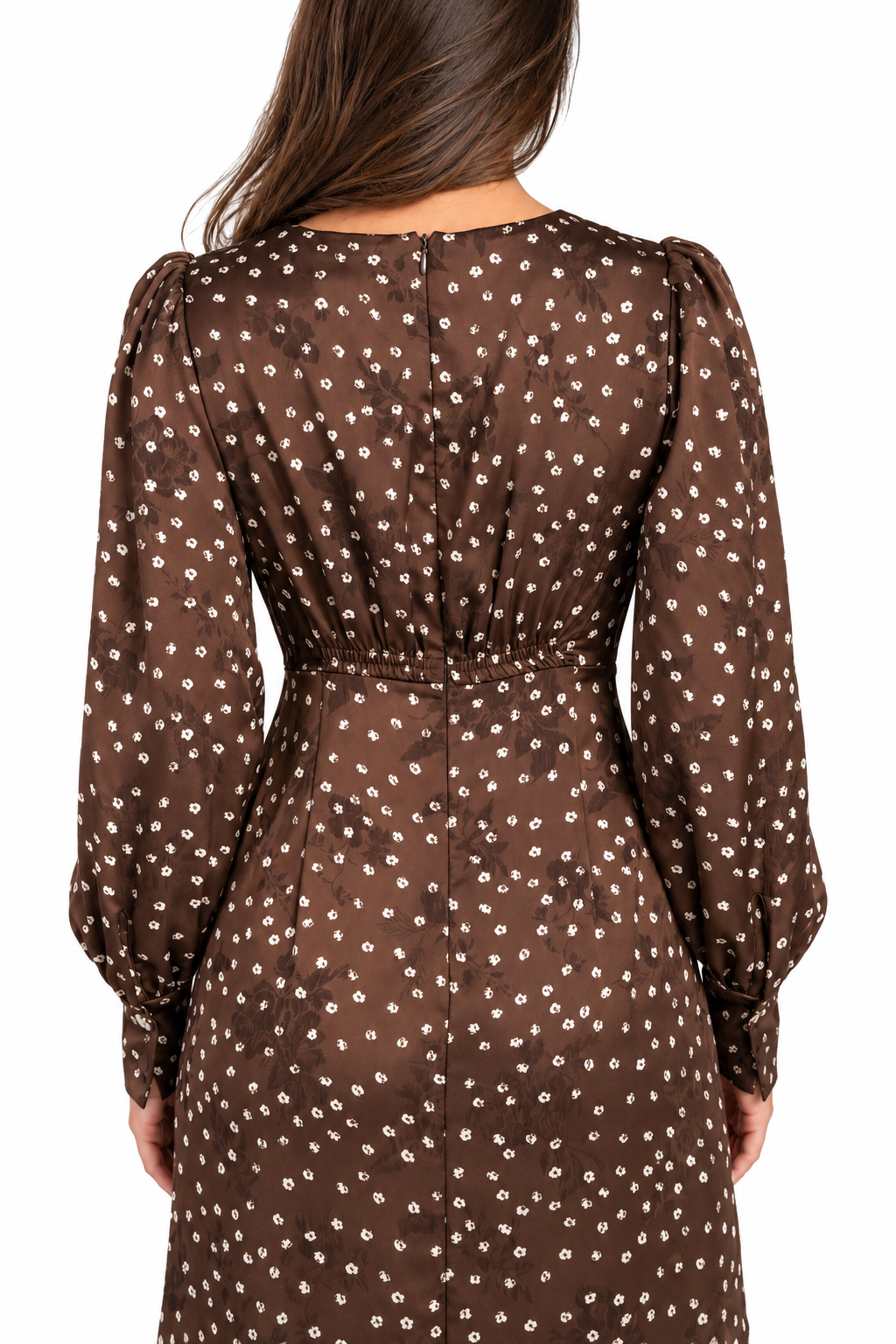 A woman viewed from the back wearing a brown long-sleeve dress with a small white floral print, set against a plain white background.
