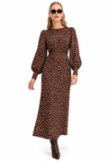 A woman modeling a long brown midi dress with a white polka dot pattern, featuring balloon sleeves and a gathered waist, paired with dark brown ankle boots and sunglasses against a plain white background.