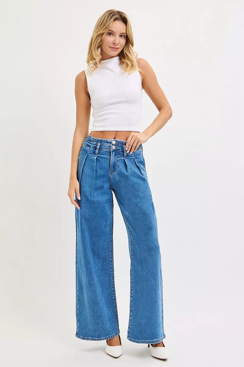 Model in On the Rise Wide Leg Pleated Jeans in heels and white background