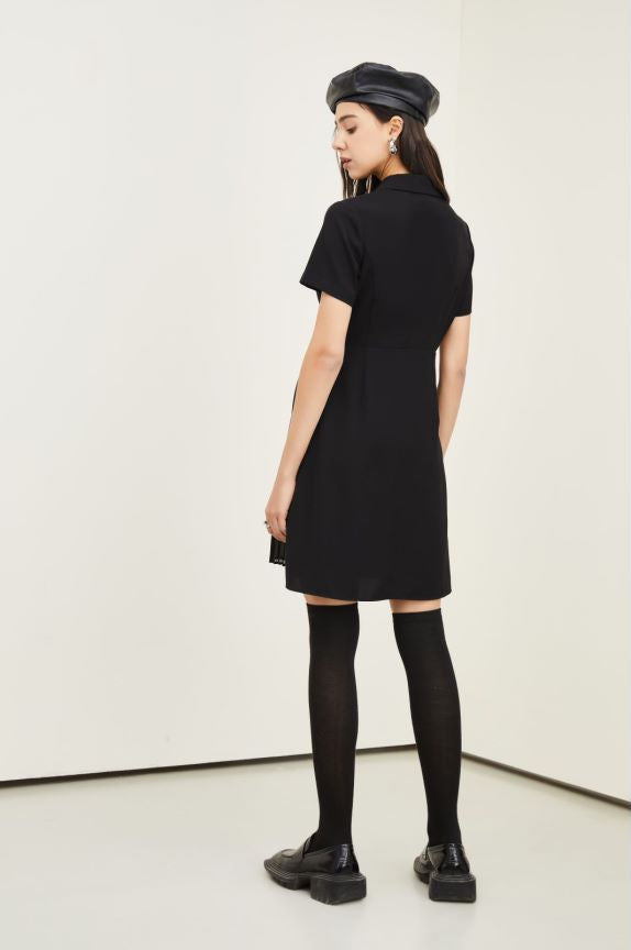 Person wearing a black dress and black shoes on a white background