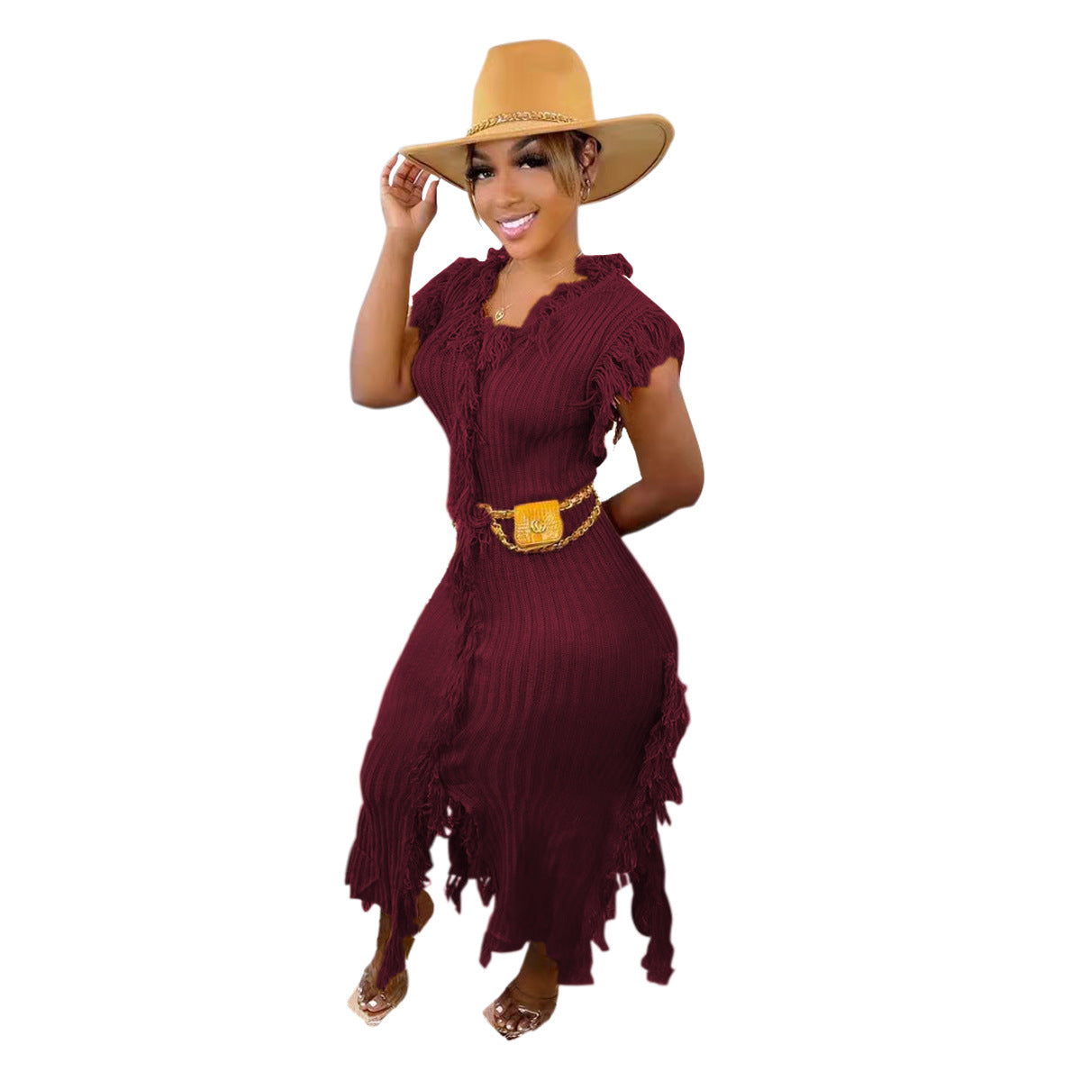 A woman modeling a maroon fringed maxi dress with a matching belt and a wide-brimmed tan hat, set against a plain white background.