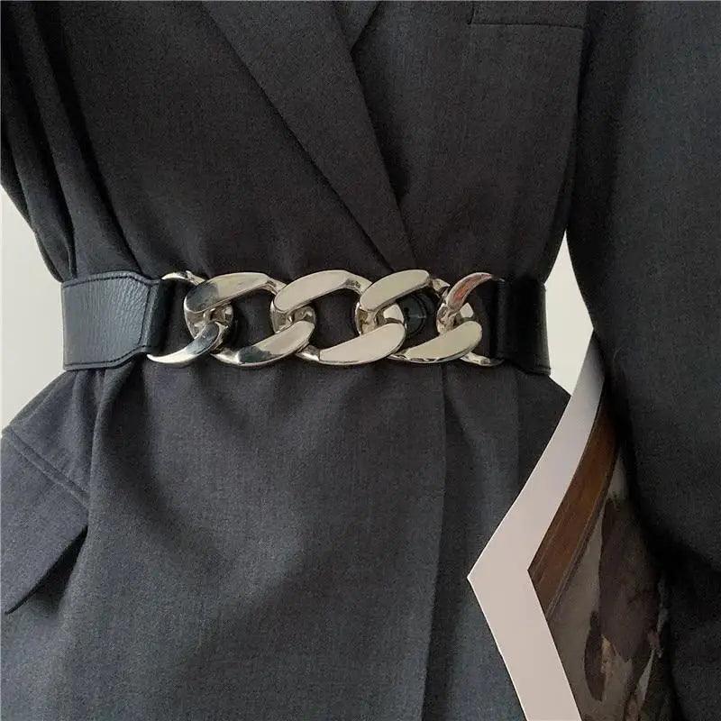 Dark coat with a chain belt on a neutral background
